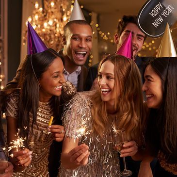 A group of people are celebrating the new year 's eve with sparklers and champagne.