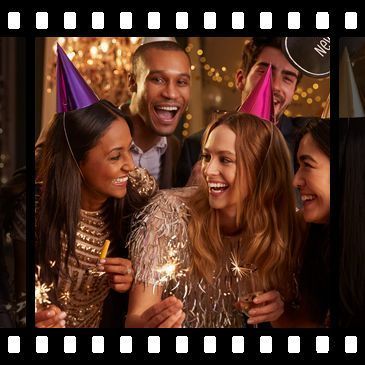 A group of people are celebrating the new year 's eve with sparklers and champagne.