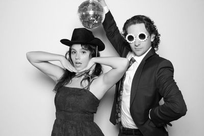 A black and white photo of a man and woman holding a disco ball.