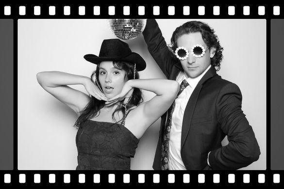 A black and white photo of a man and woman holding a disco ball.