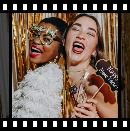 Two women holding a sign that says happy new year