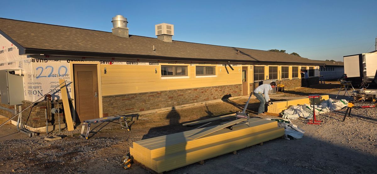 Exterior of a building under construction, yellow and brown colors, with a person working outside.