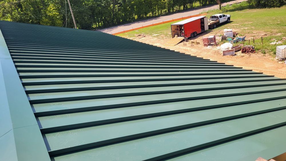 Green metal roof with horizontal lines, construction site background.