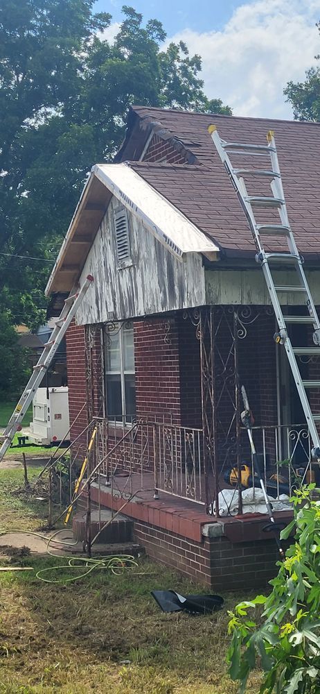A weathered brick house with two ladders propped against the roof. The front porch is visible.