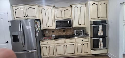 Kitchen with off-white cabinets, stainless steel appliances, and a microwave and double oven.