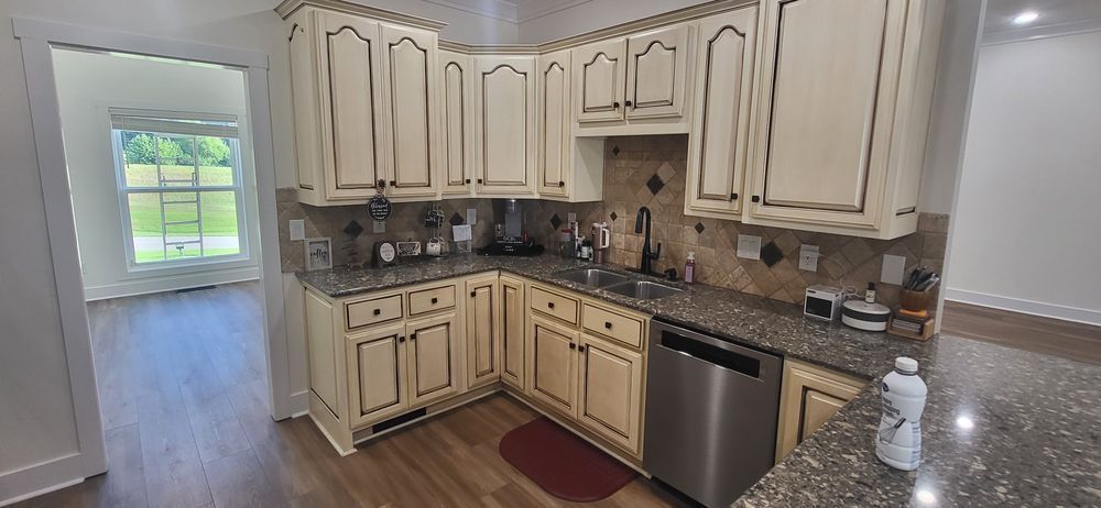 Corner kitchen with cream cabinets, granite countertops, and stainless steel dishwasher.
