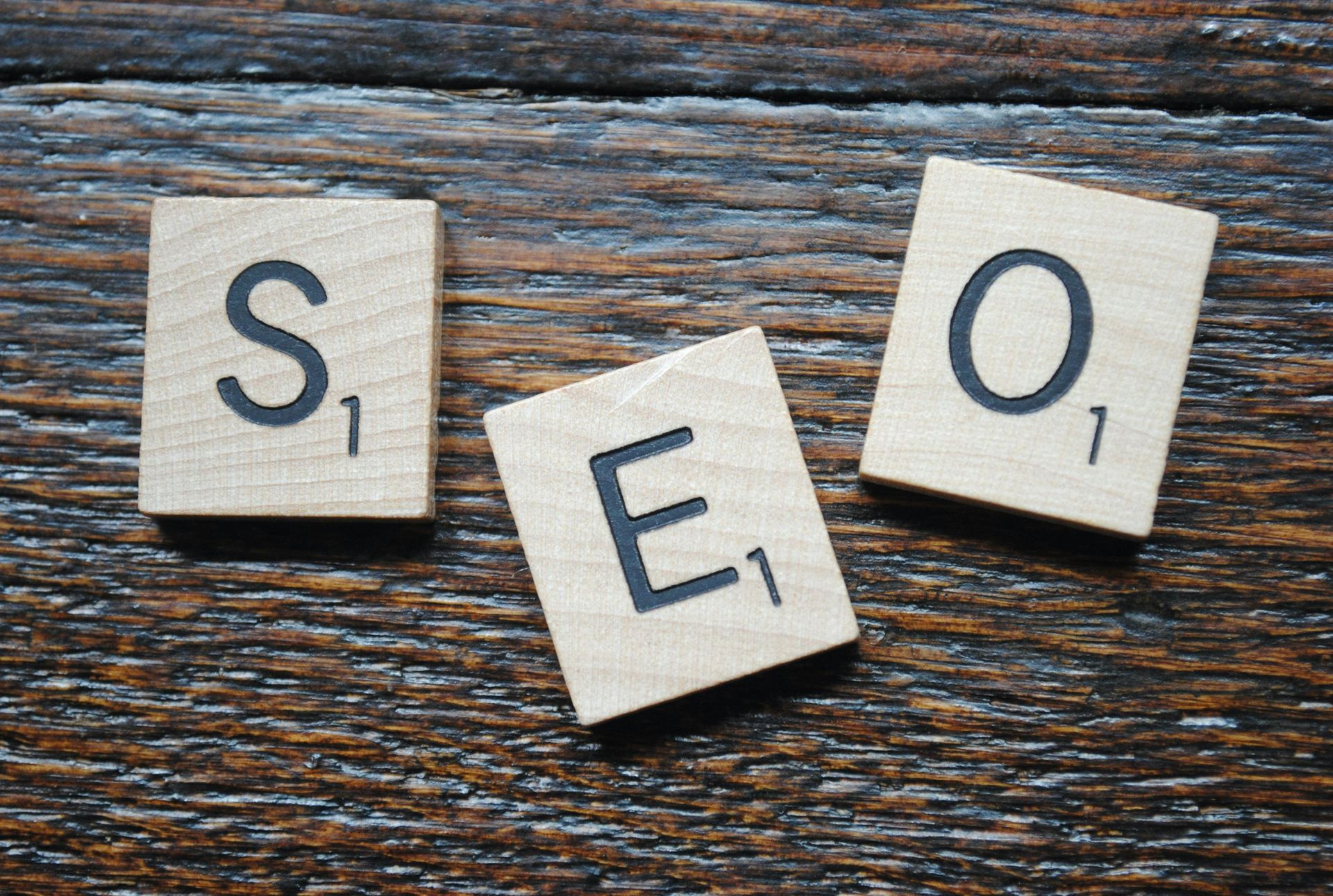 La palabra SEO está escrita en fichas de Scrabble sobre una mesa de madera.