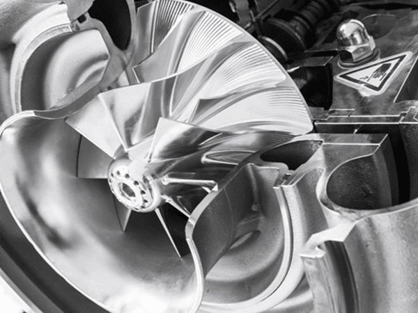 Un primer plano de un turbocompresor en una fotografía en blanco y negro.