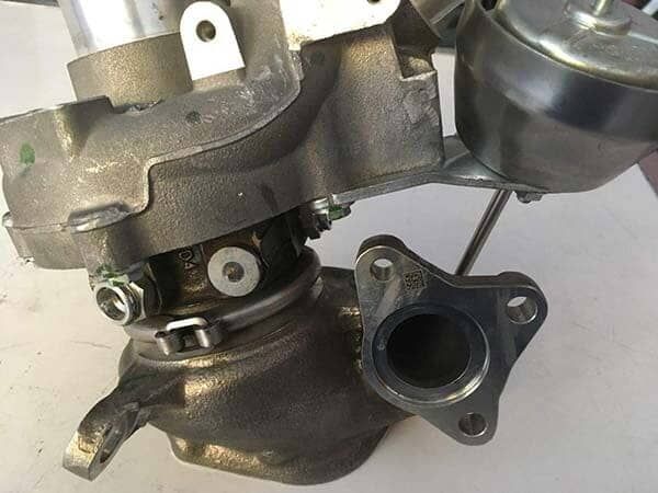 Un primer plano de un turbocompresor sobre una superficie blanca.