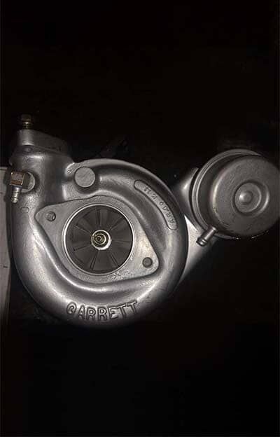 Un primer plano de un turbocompresor sobre un fondo negro.