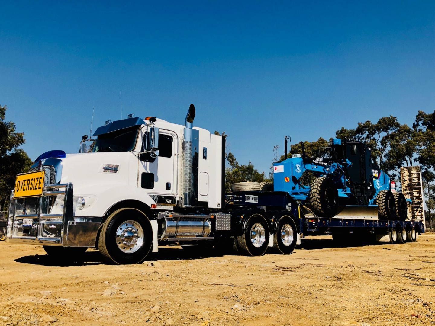 Blue Grader on Trailer Truck — Marulan, NSW — Coopers Earthmoving Pty Ltd