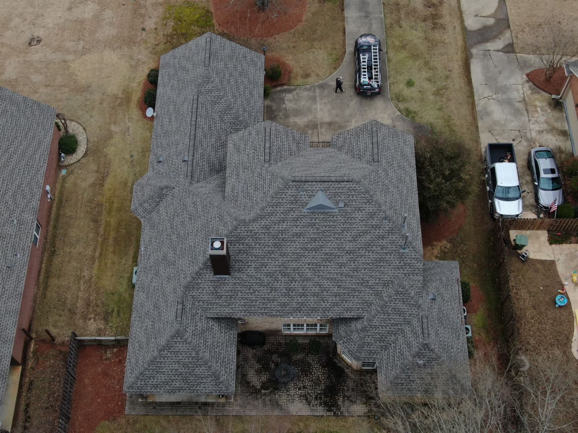 A skilled worker repairs a roof using tools and materials, ensuring its durability and structural integrity.
