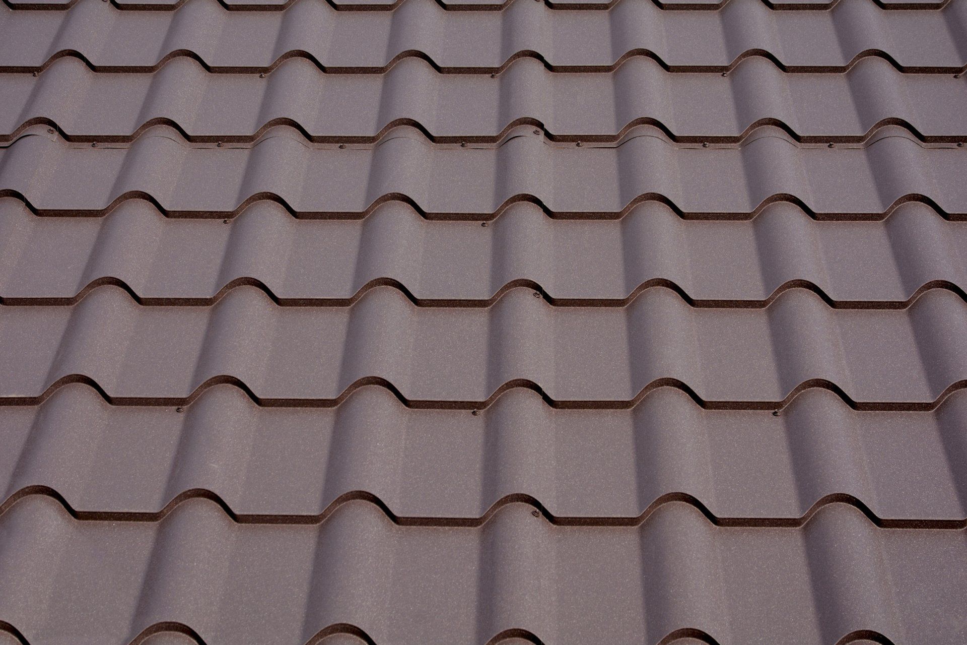 A close-up view of a metal roof on a house, featuring interlocking metal panels