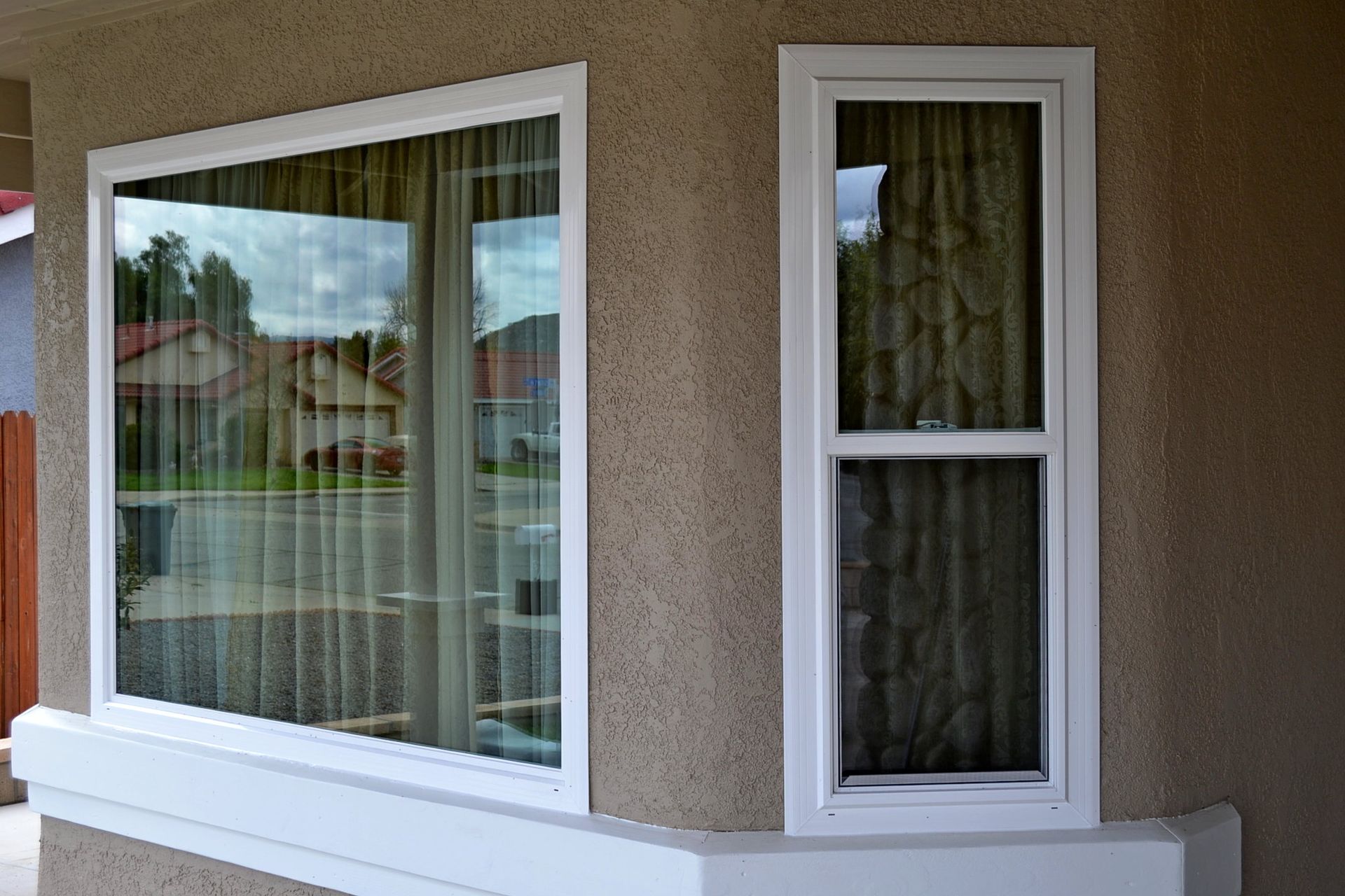 A man carefully installing hinges on a window frame with focused precision.