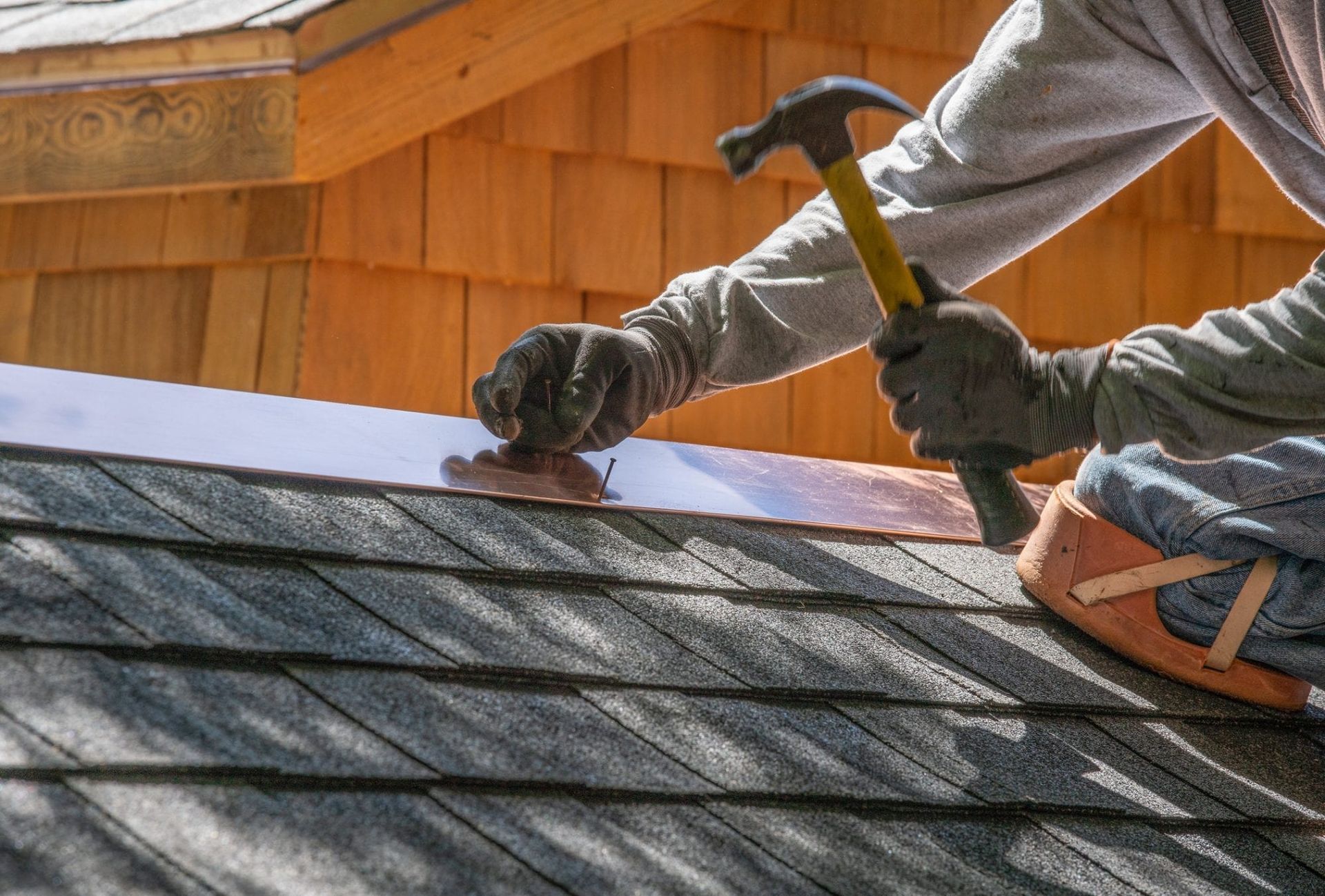 A man is working on the roof of a house.