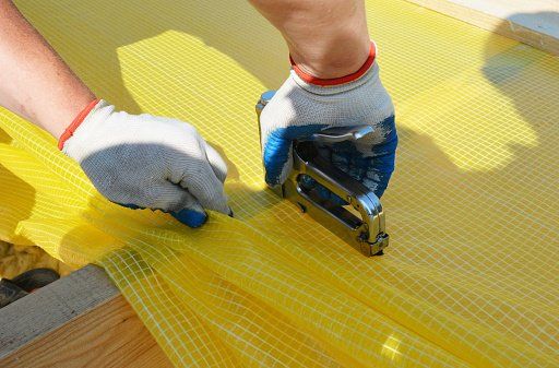 A worker carefully cutting a protective film with precision.