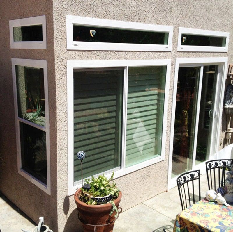 A young man is installing a bay window in a new house construction site.