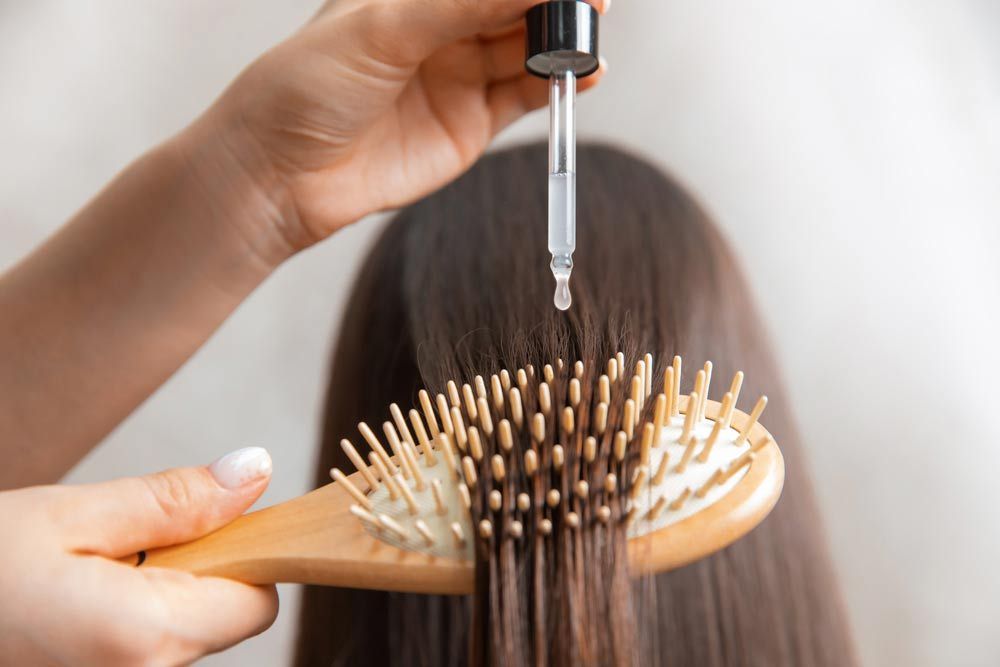 Hair Stylist Applying Anti Hair Loss Solution To A Client's Hair