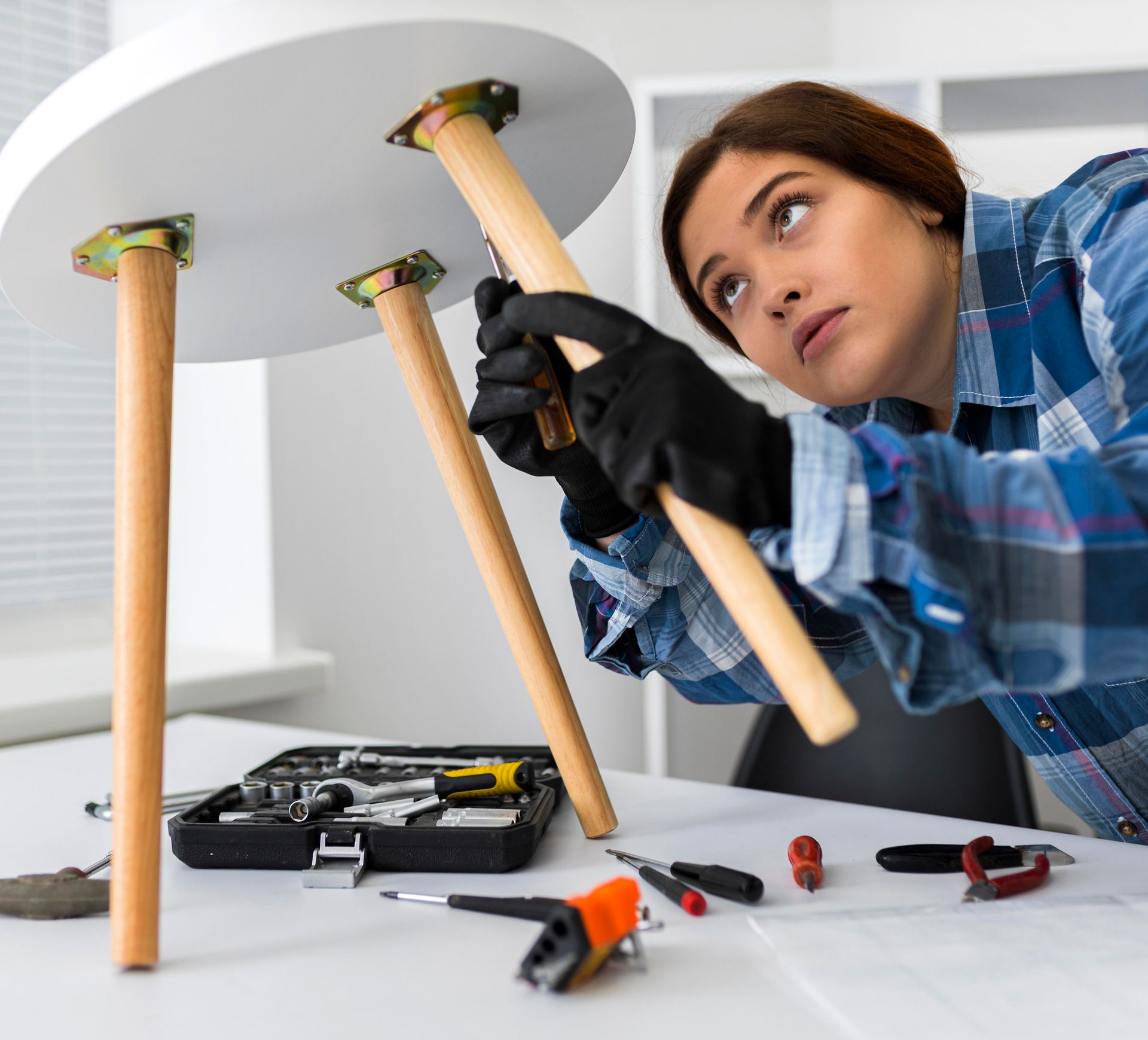A woman in a plaid shirt is working on a table