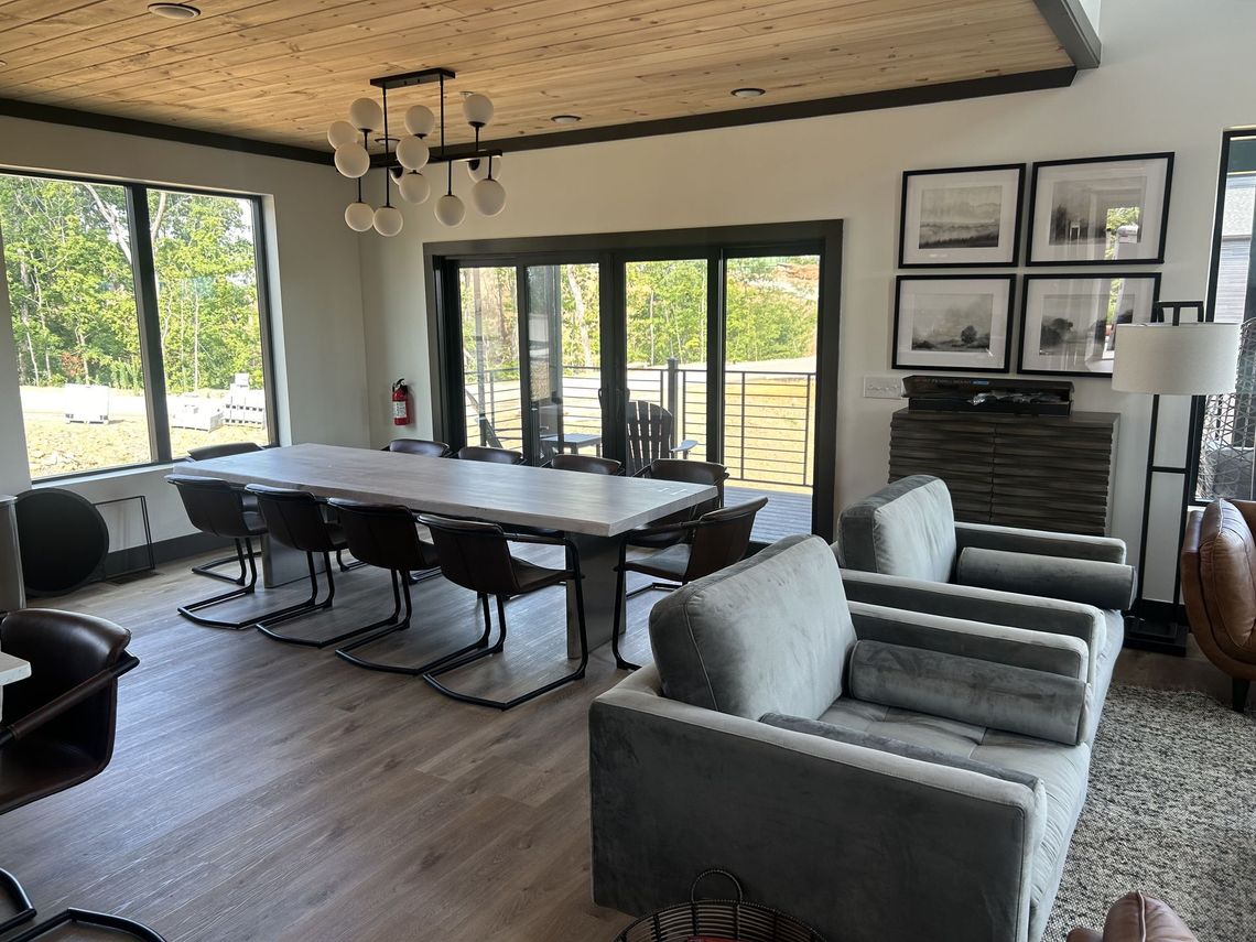 A living room with a table , chairs , and a chandelier.