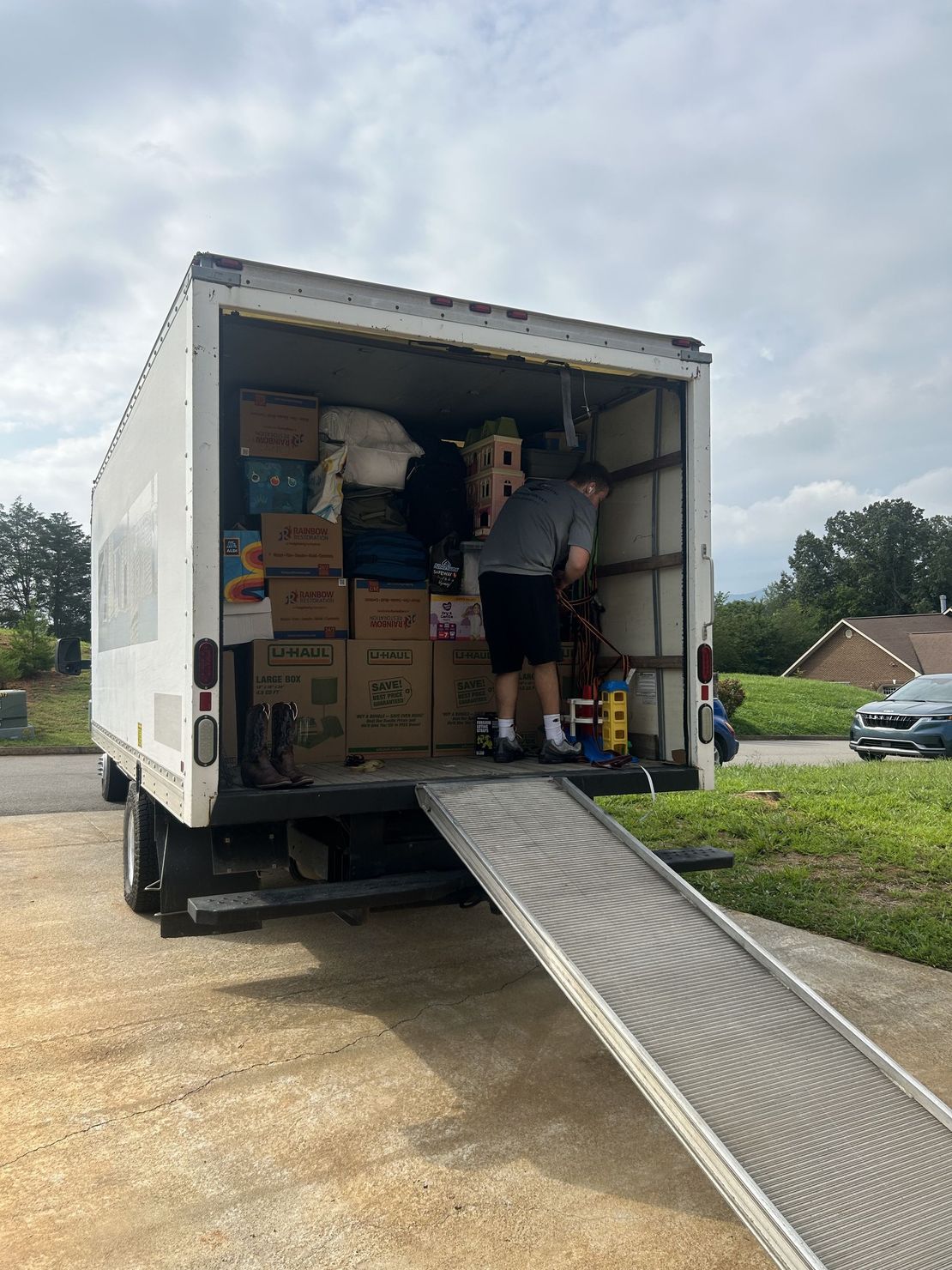 A man is loading boxes into a moving truck.