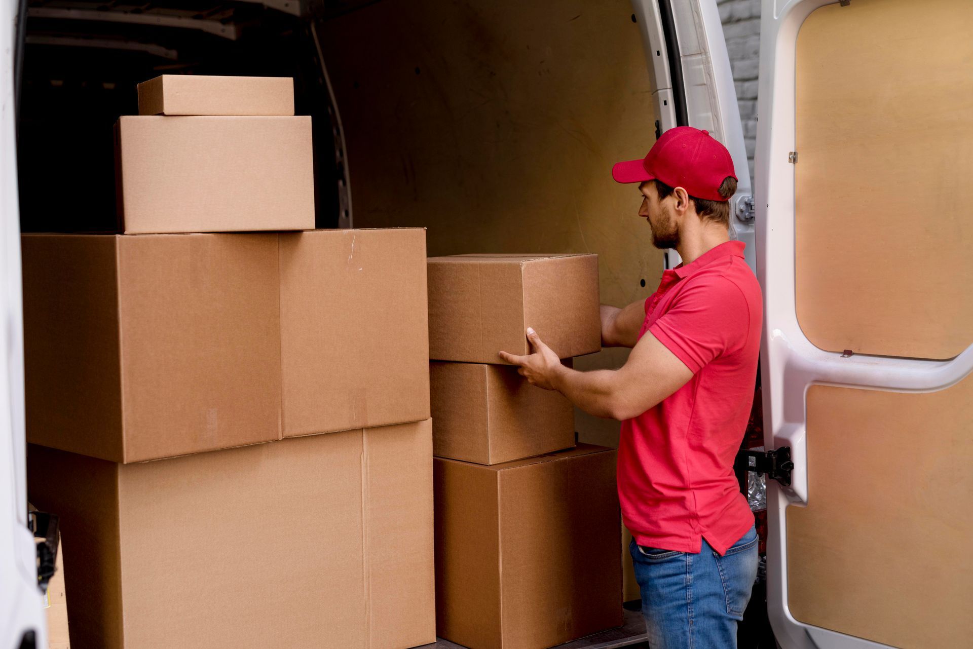 A delivery man is loading boxes into a van.