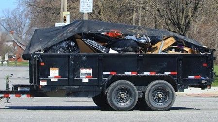 Cargo trailer being pulled with garbage and debris