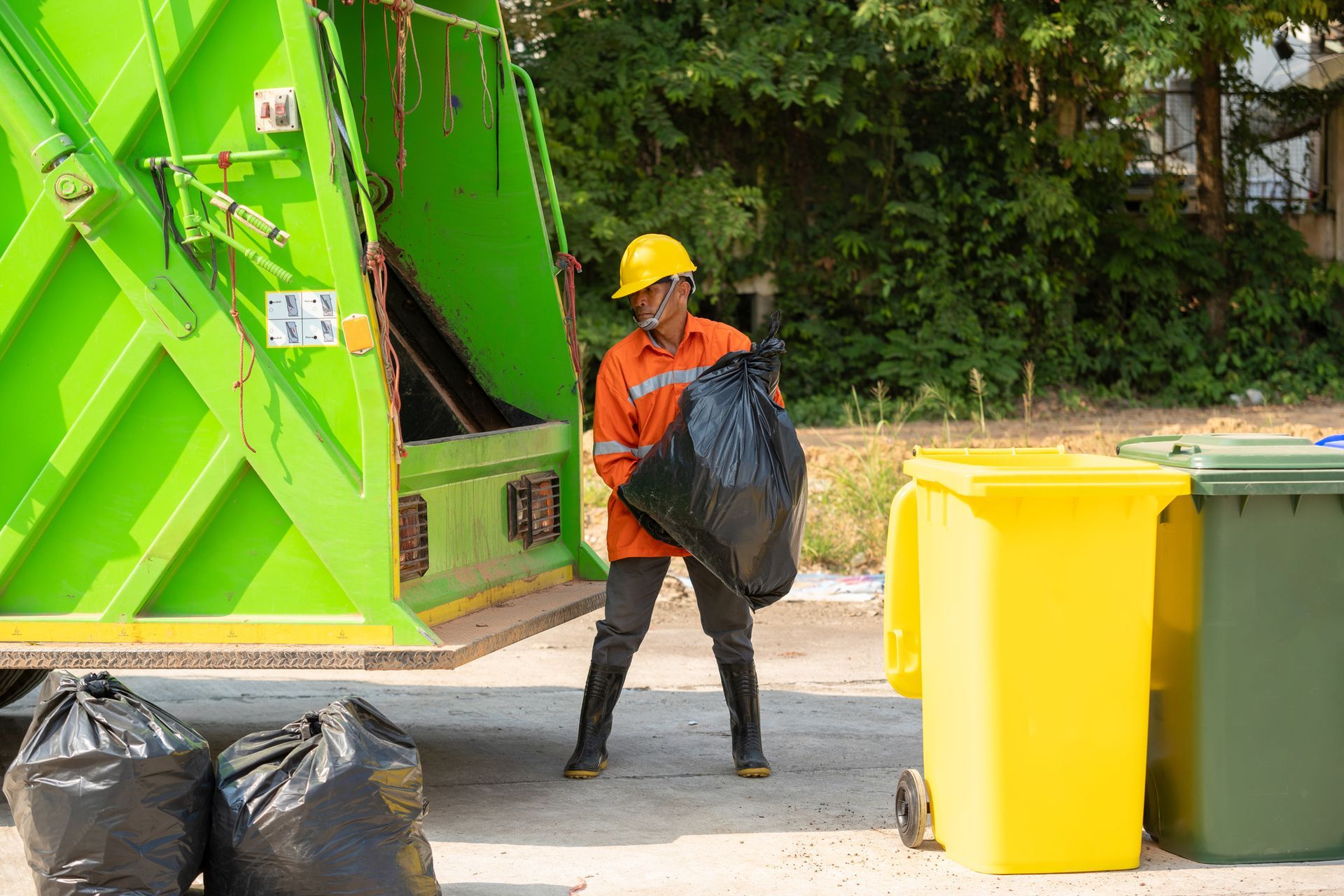 Worker operating garbage collector truck for efficient trash removal.