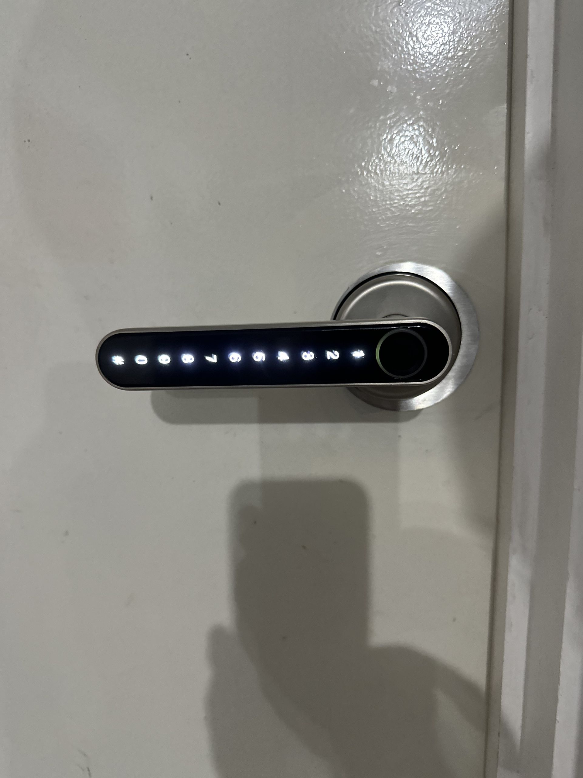 A person is holding two remote keys in front of a black car.