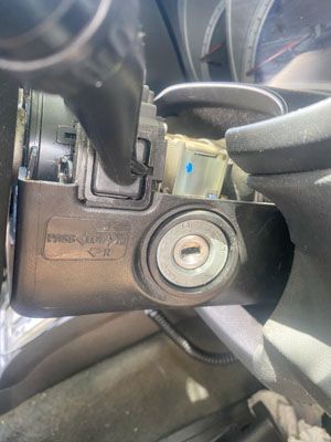 A close up of a car steering wheel with a key in it.