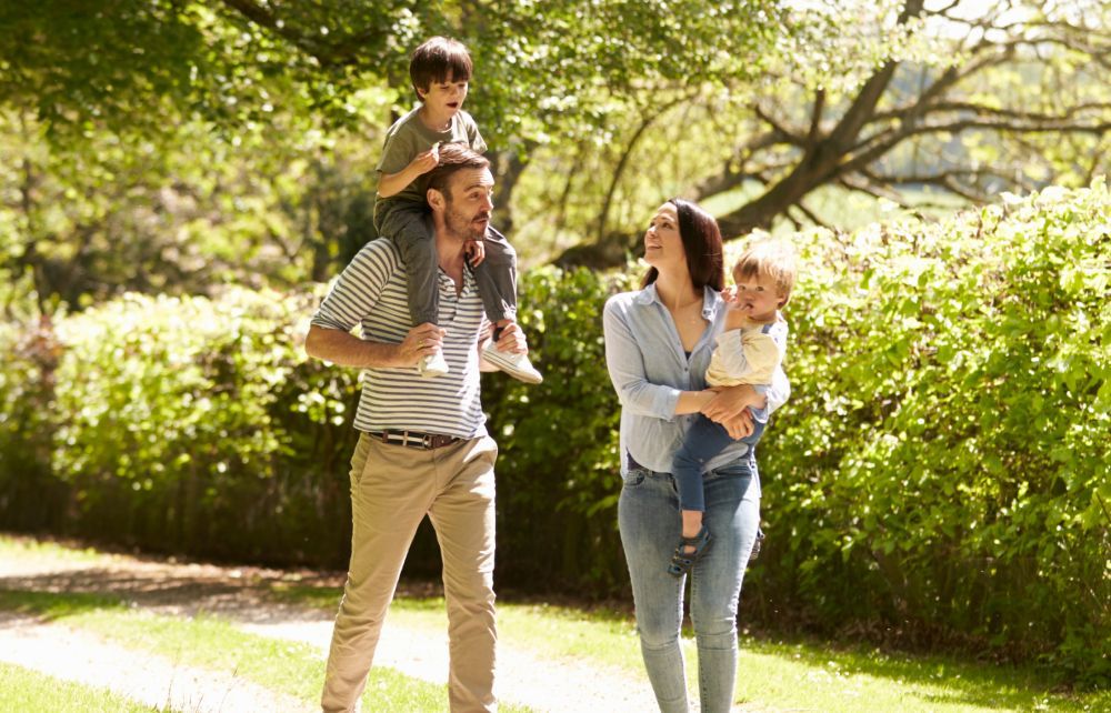 A family is walking down a path in a park.