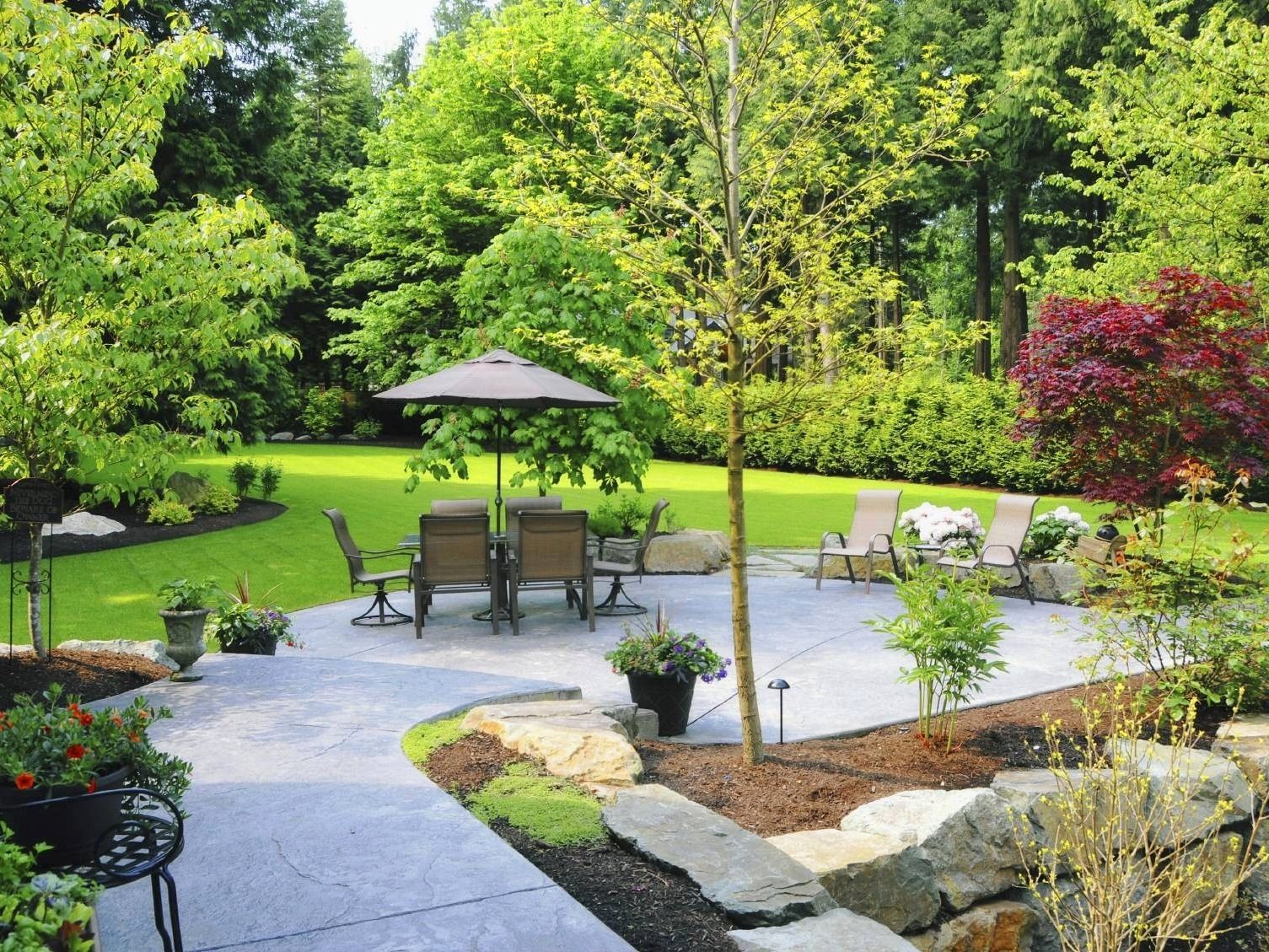 A patio with a table and chairs and an umbrella