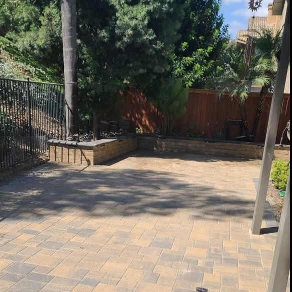 A brick patio with a wooden fence in the background
