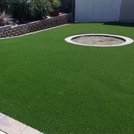 There is a fire pit in the middle of the grass.