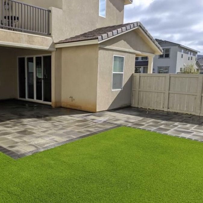 A house with a patio and a lawn in front of it.