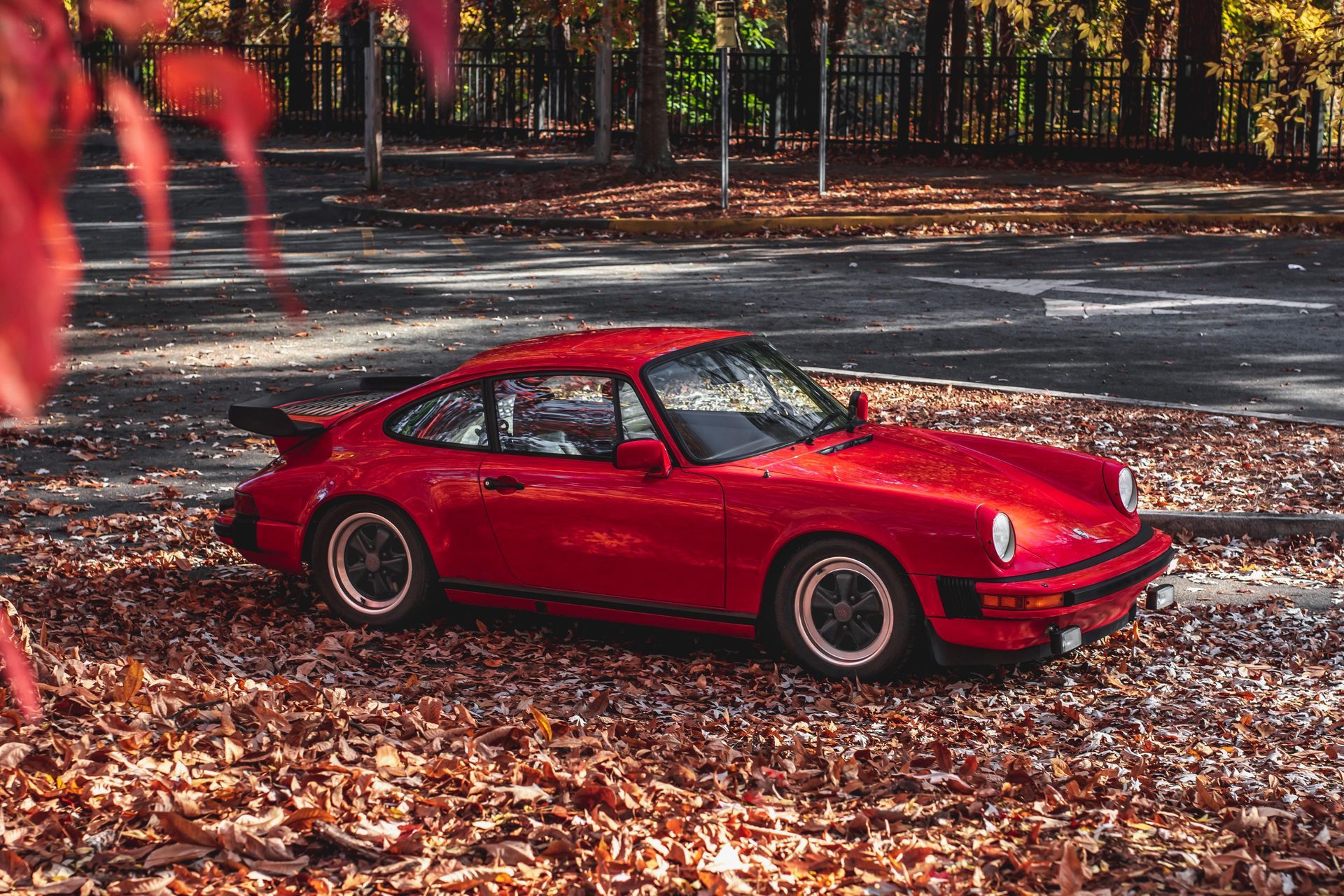 A classic red Porsche 911 SC detailed to perfection, parked among autumn leaves in Northern Atlanta.