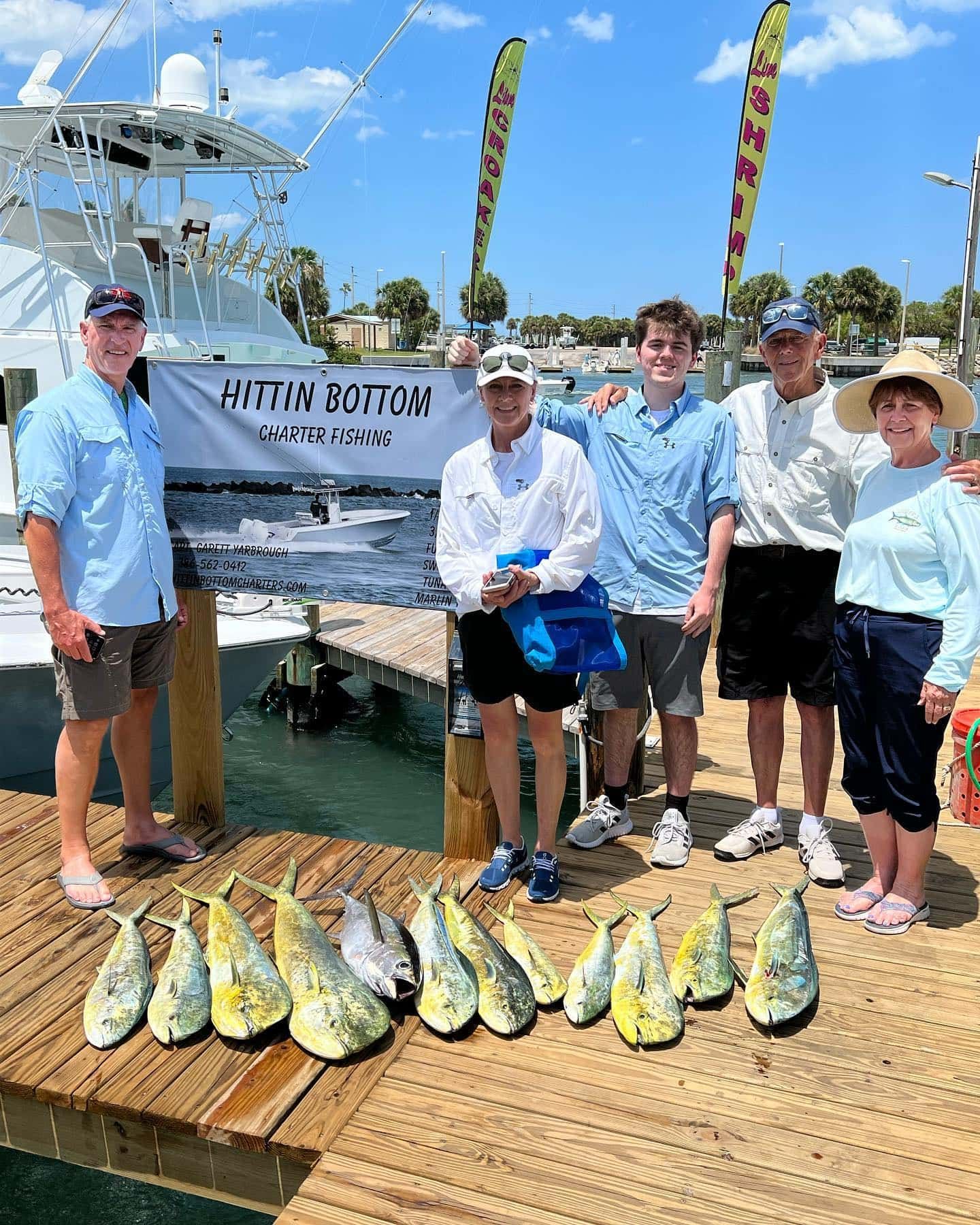 A group of people are standing on a dock next to a boat.
