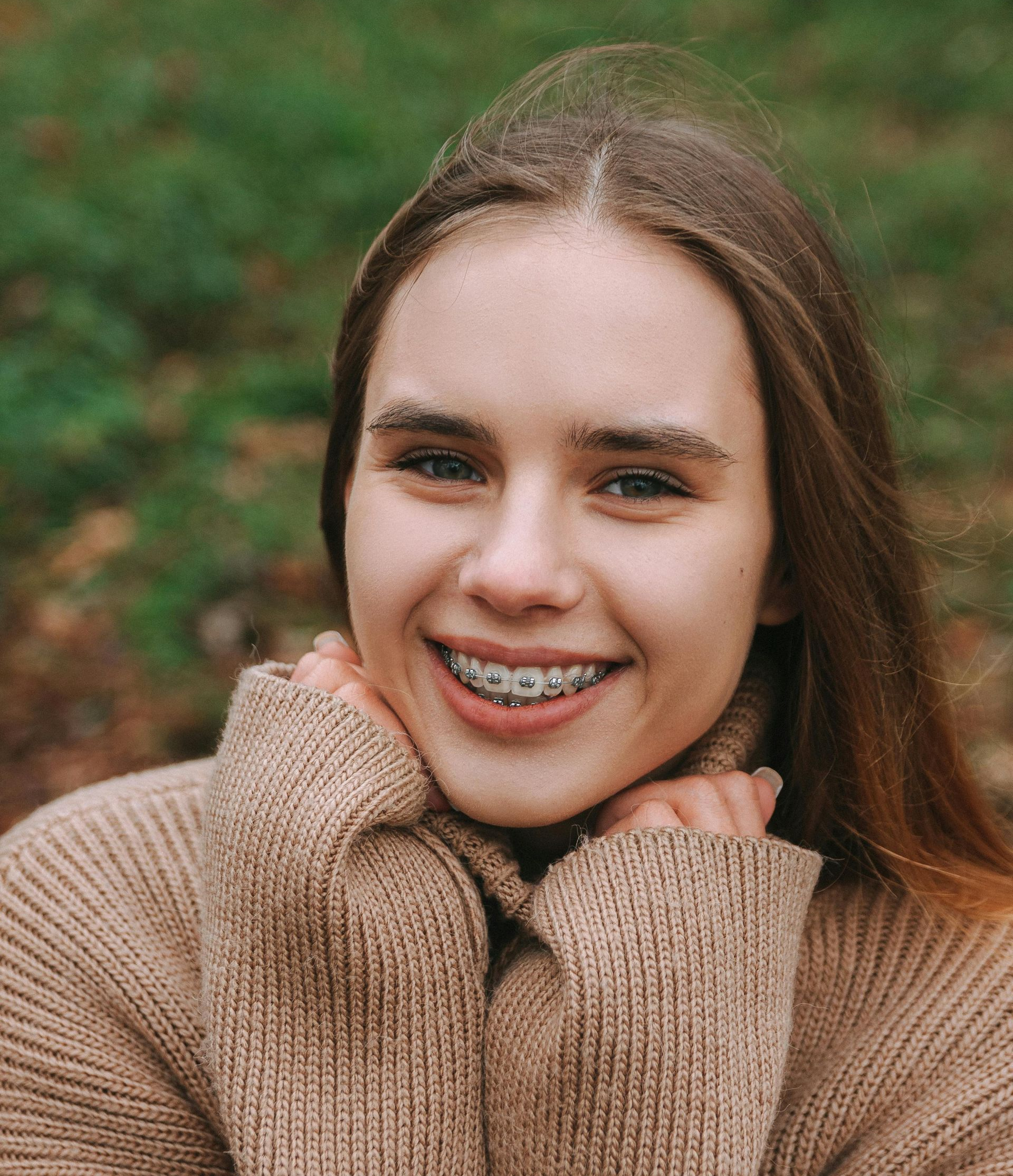 A young woman is smiling with braces