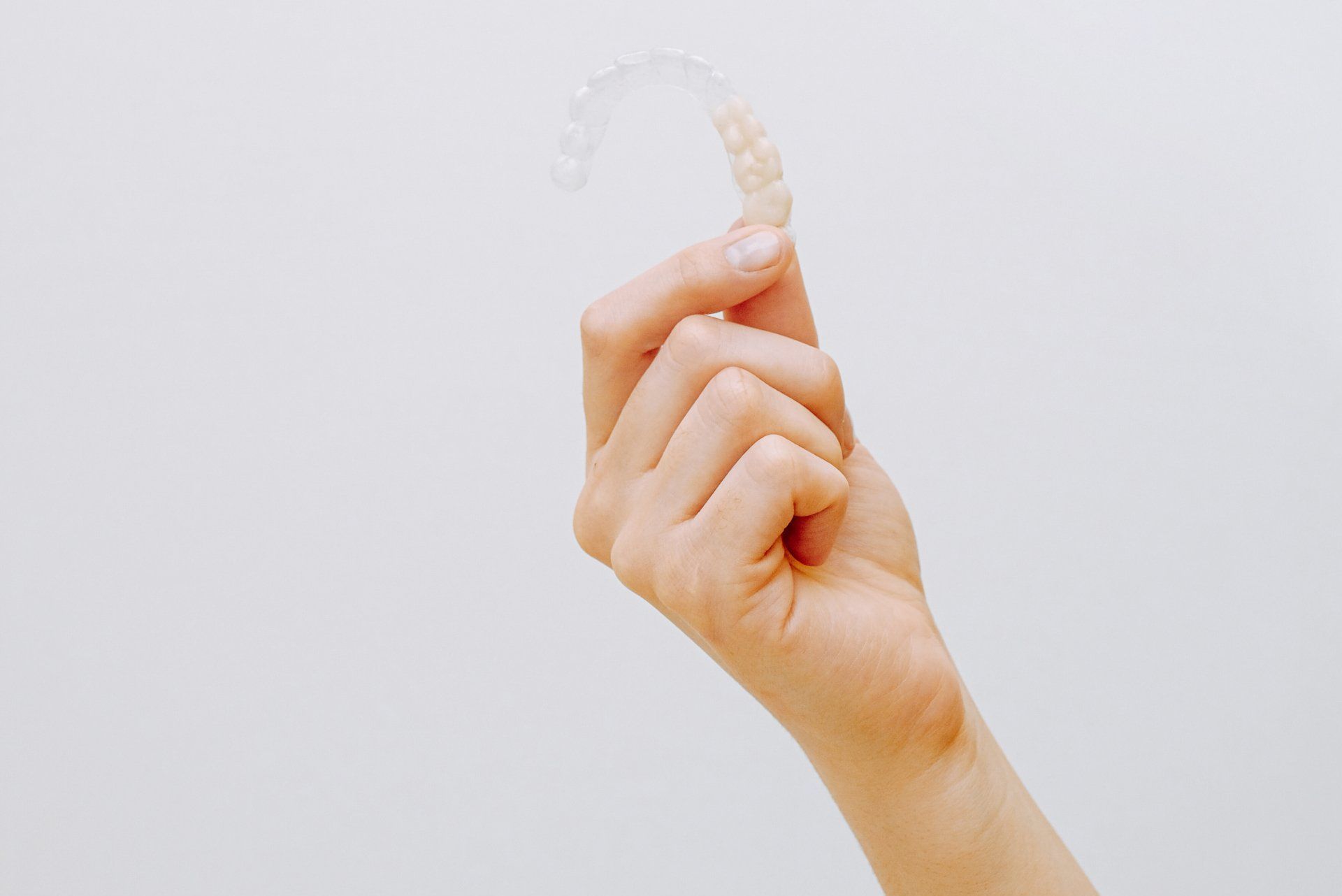 a woman 's hand is holding a clear plastic object
