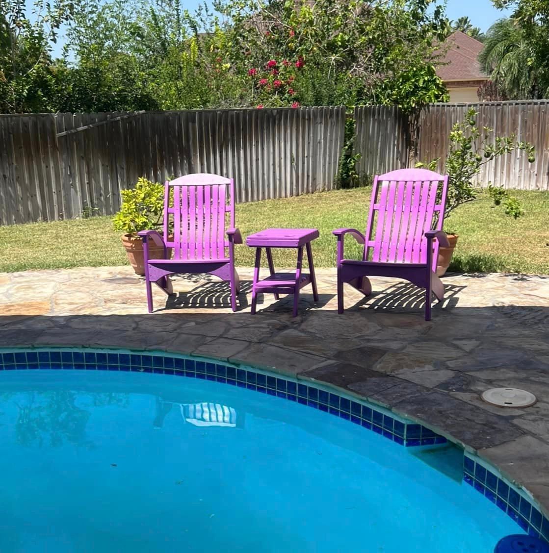 Two purple chairs are sitting next to a swimming pool