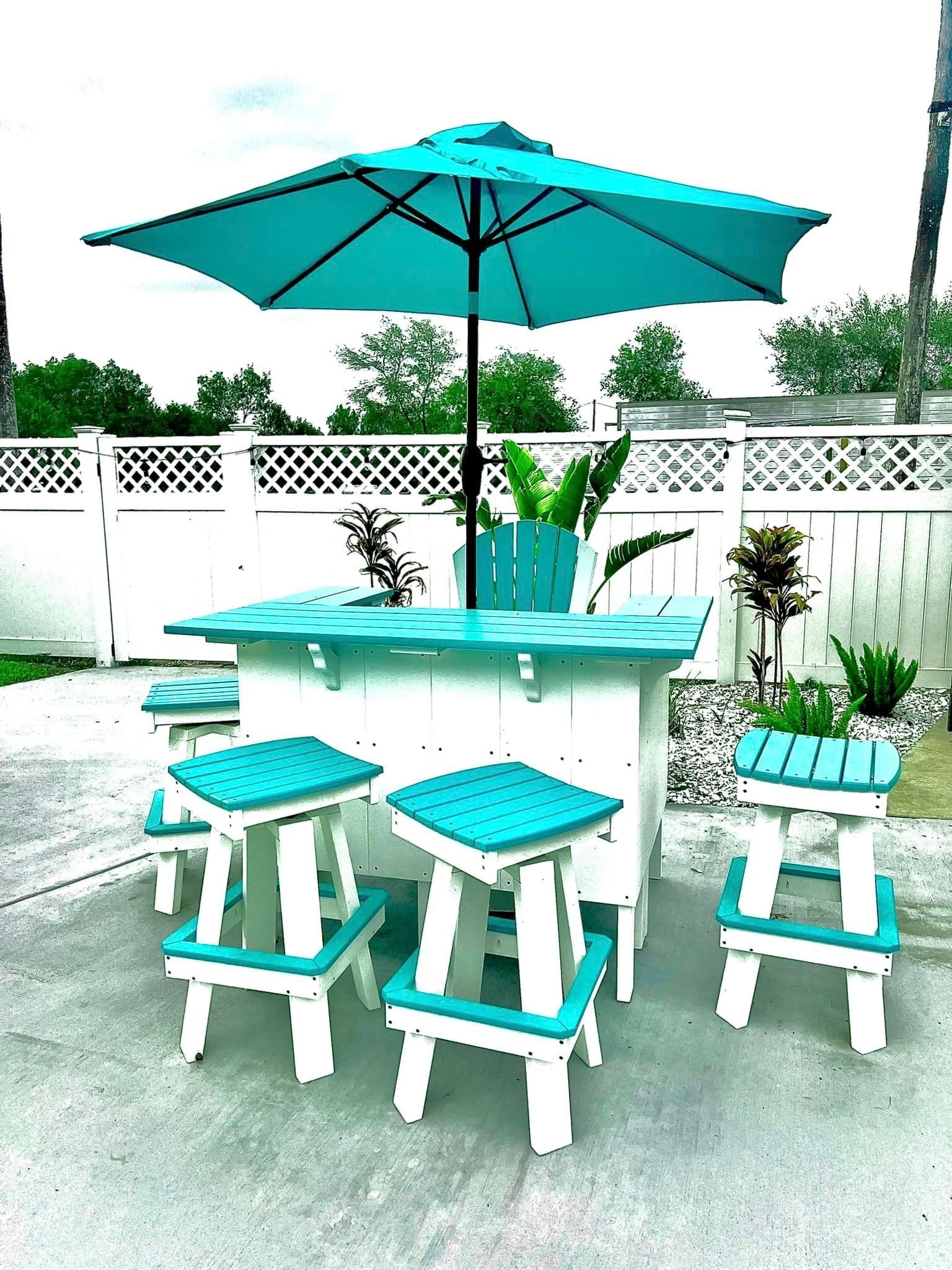 A white table with blue stools and a blue umbrella