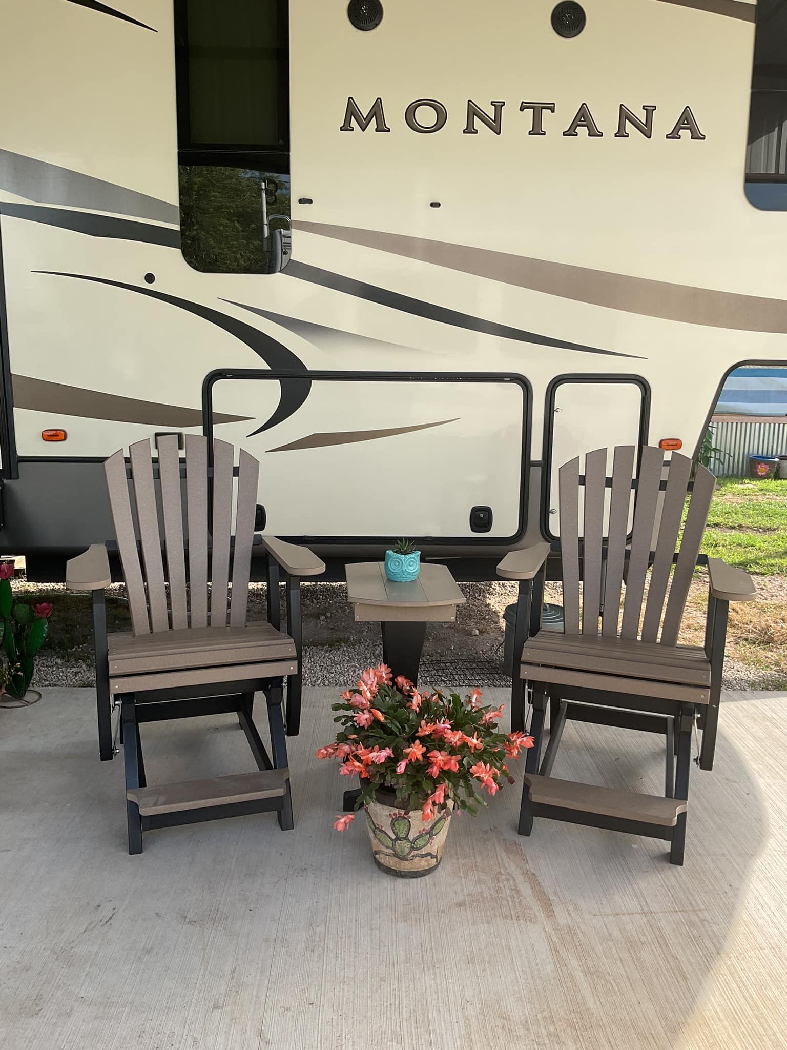 Two chairs and a table in front of a montana trailer.