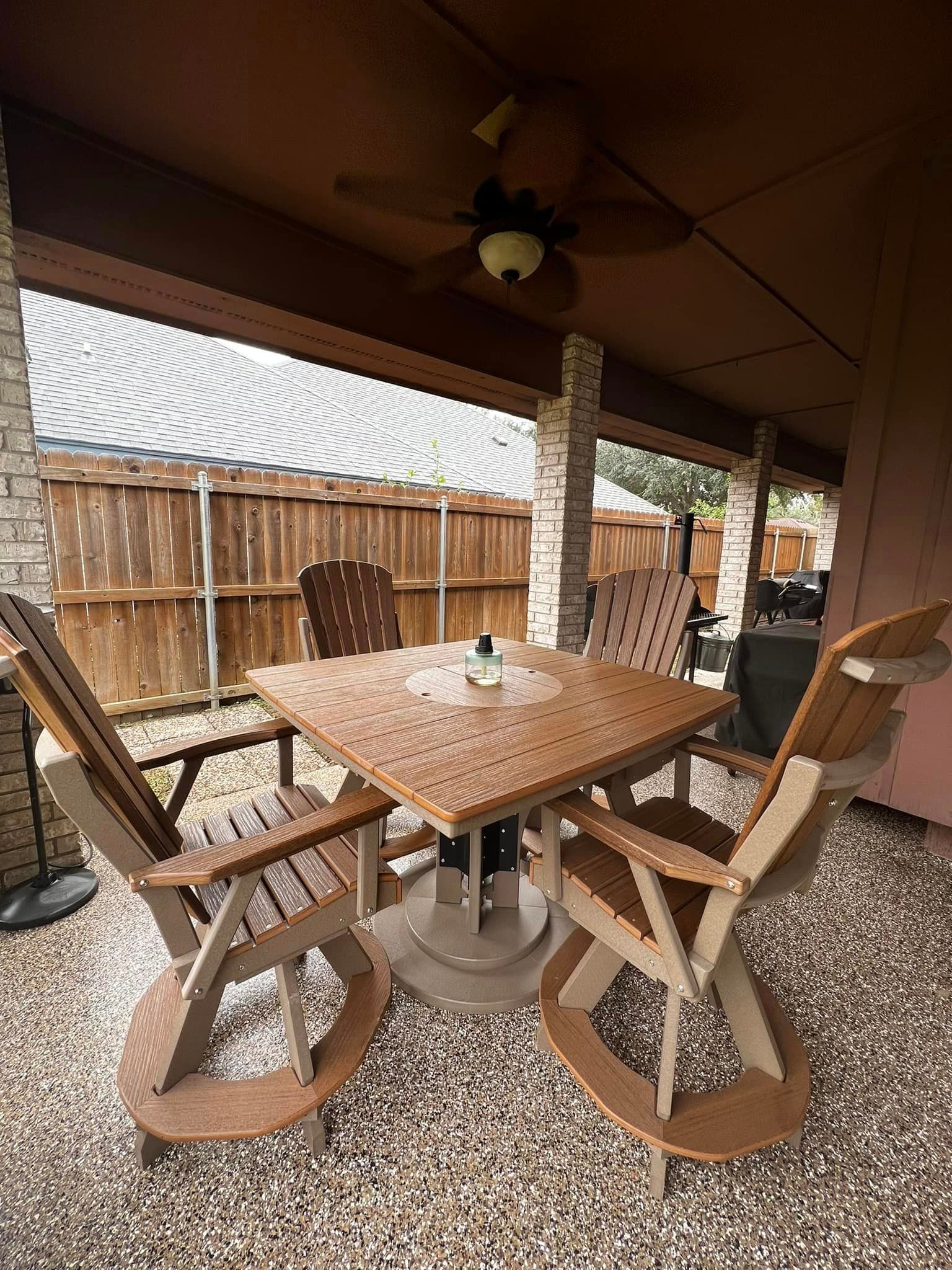 A patio with a table and chairs under a ceiling fan.