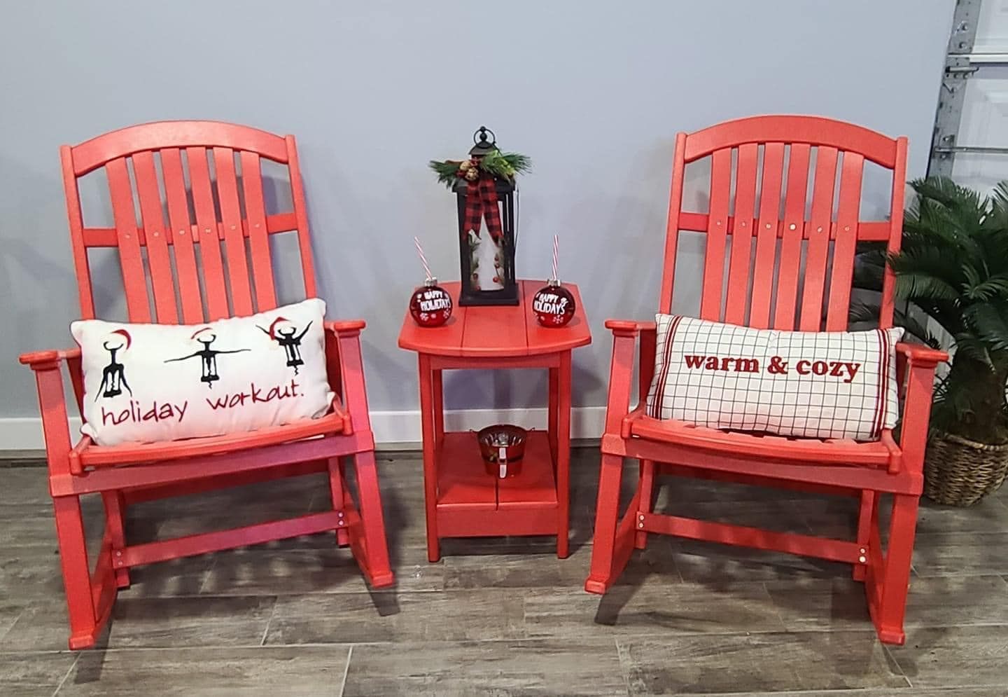 Two red rocking chairs with pillows on them are sitting next to each other in a room.