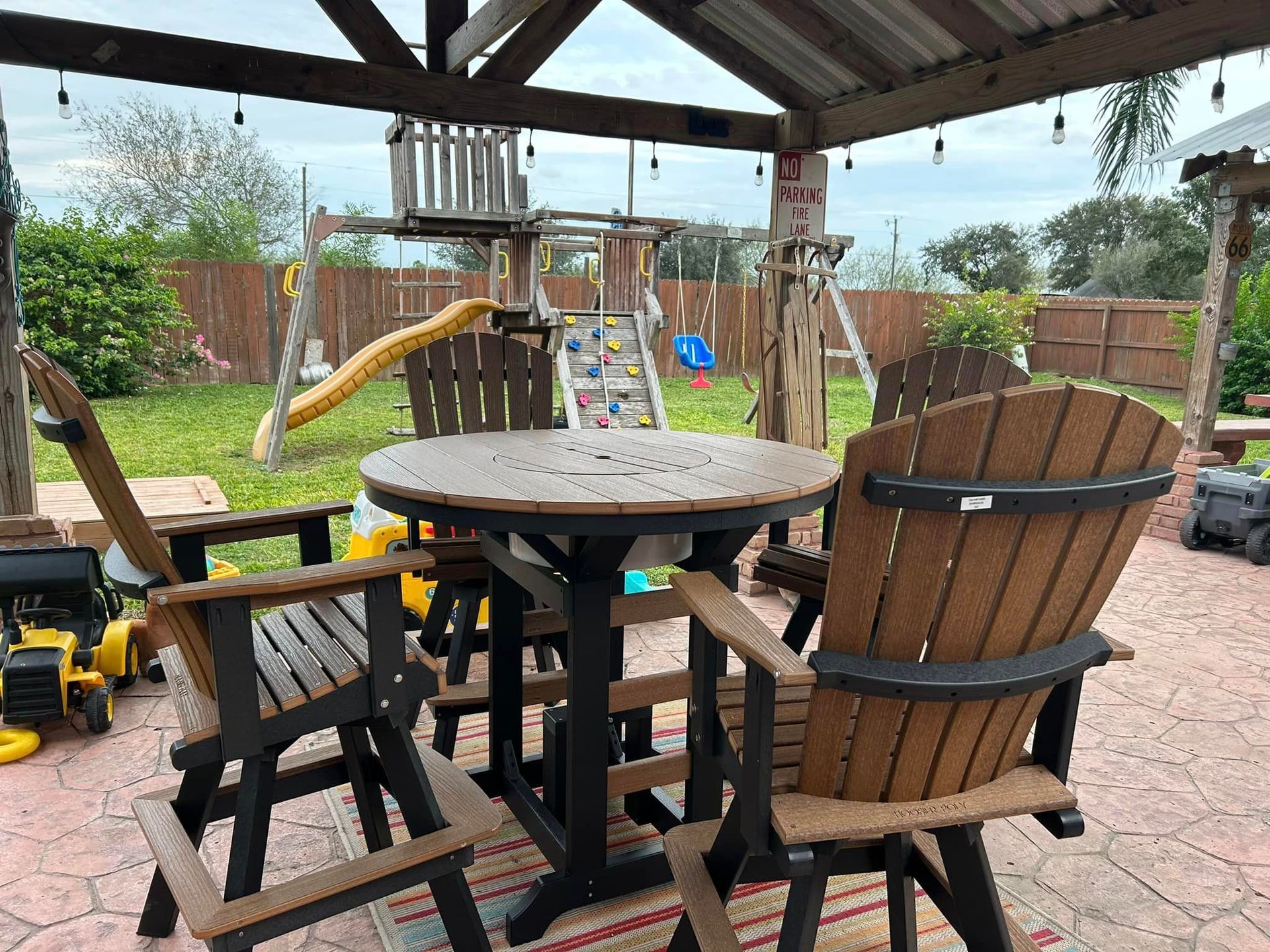 A patio with a table and chairs and a playground in the background.