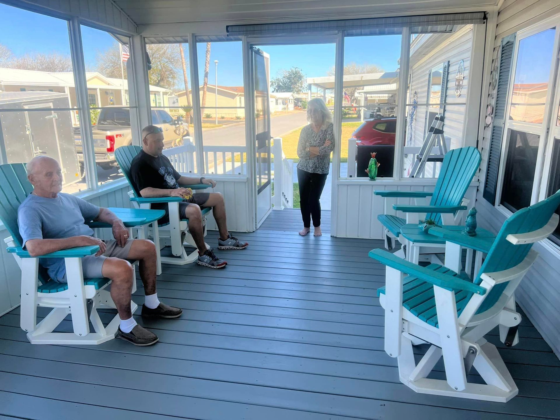 A group of people are sitting in chairs on a porch.