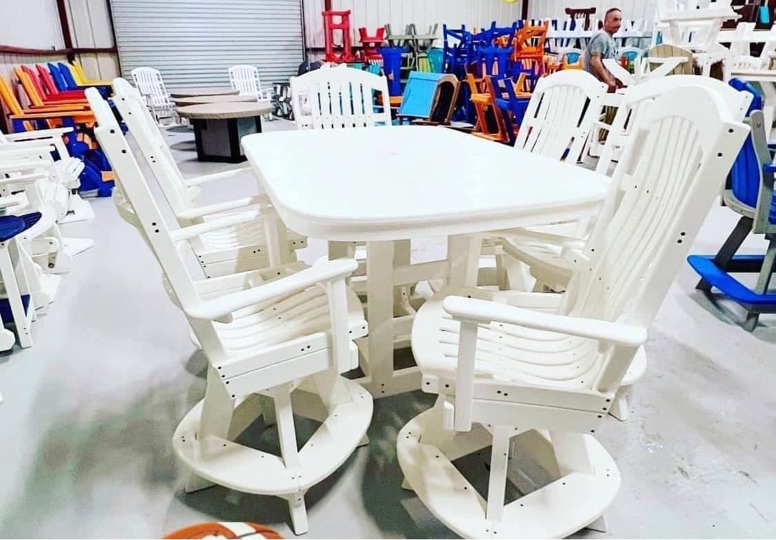 A white table and chairs are sitting in a warehouse.