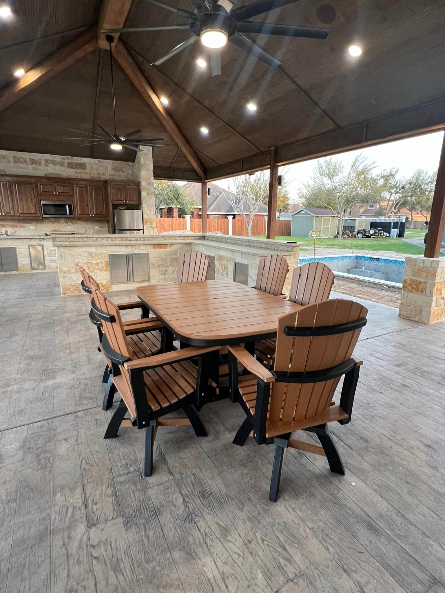 A patio with a table and chairs under a gazebo.