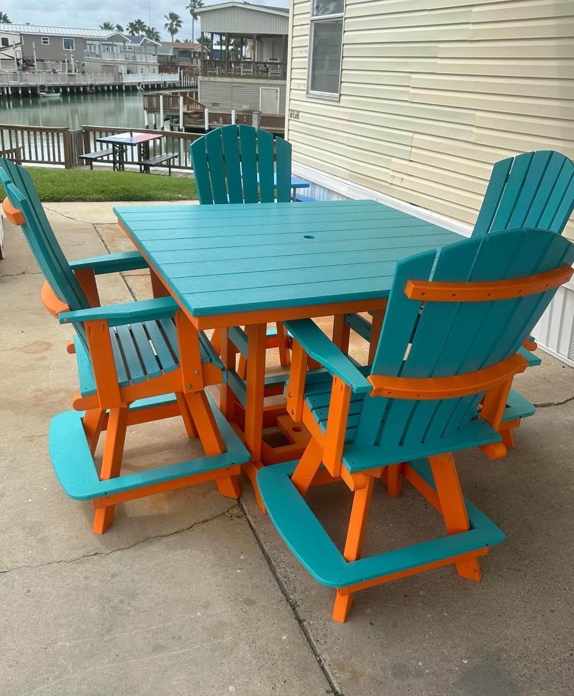 A patio set with a blue table and orange chairs