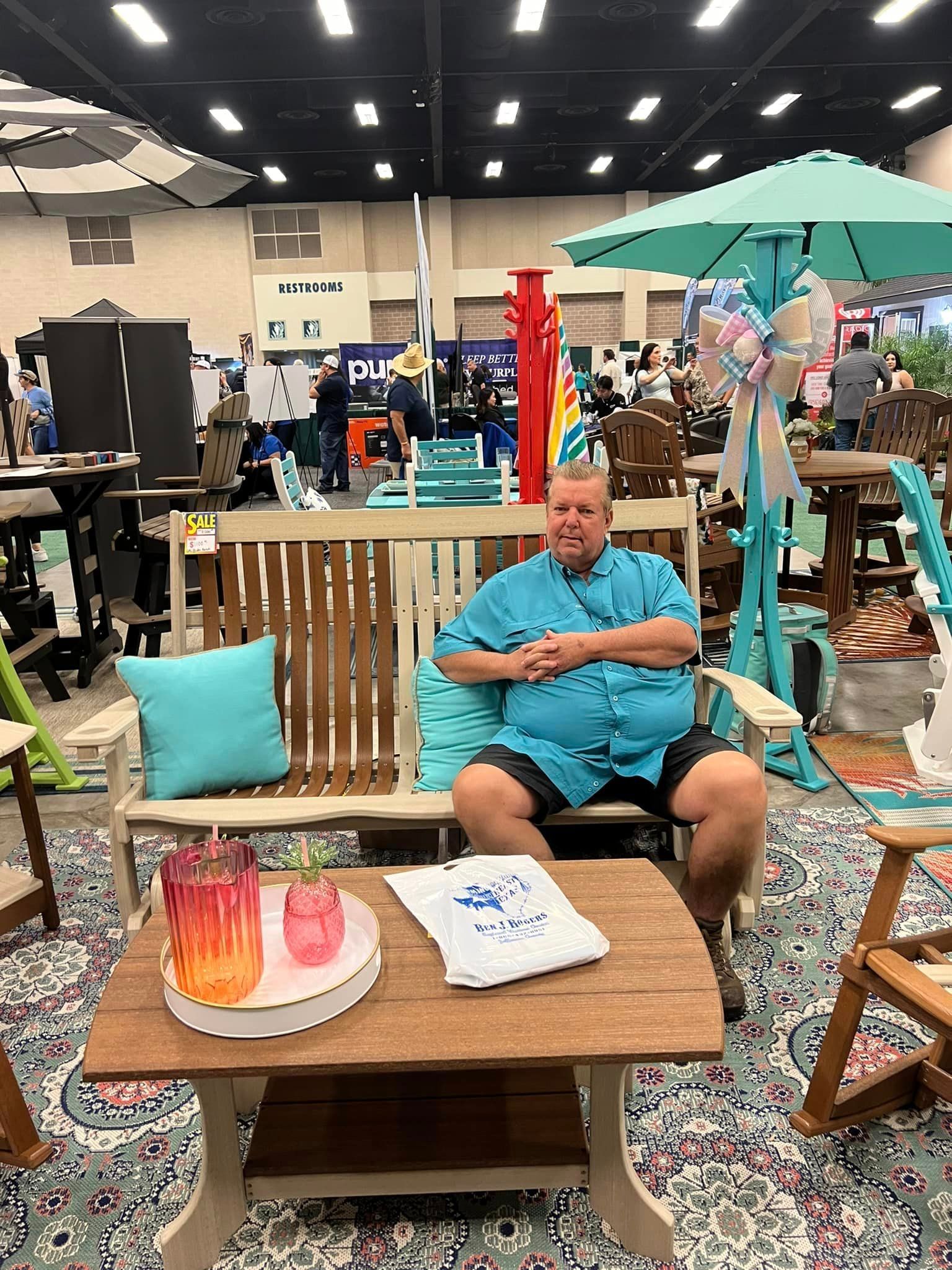 A man is sitting on a bench in a room with a table and chairs.